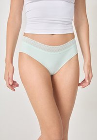 Braguitas de algodón verde menta con cintura de encaje, que cuentan con una textura suave y un diseño de corte clásico sin adornos visibles.