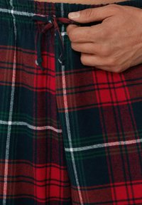 Czerwono-granatowe szorty w kratę wykonane z miękkiej flaneli, z elastycznym pasem i sznurkiem do wiązania dla lepszego dopasowania.