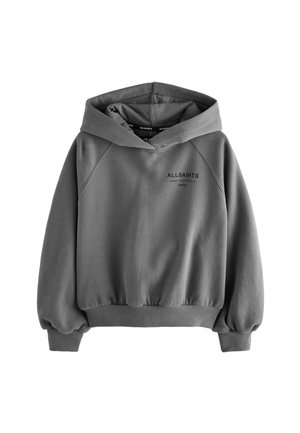 Junge Person trägt einen lockeren grauen Kapuzenpullover mit dem Text „ALLSAINTS LONDON“ und graue Cargohosen, posiert vor einem einfarbigen Hintergrund.