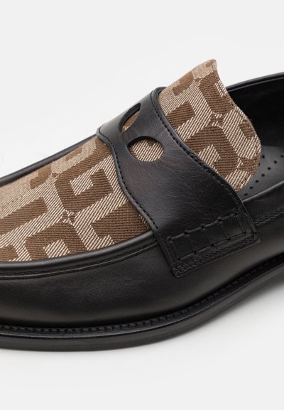 Schwarzer Lederschuh mit einem obermaterial aus braunem gemustertem Stoff, das mit einer dekorativen gesteppten Akzent und einem runden Ausschnitt an der Seite versehen ist.
