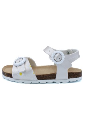 Sandale blanche ornée de motifs floraux, dotée de deux boucles réglables, d'une semelle en liège et d'une semelle extérieure blanche. Conçue pour le confort et la durabilité.