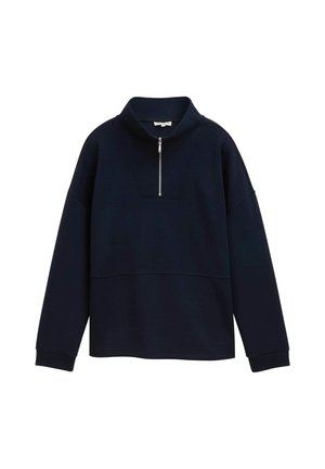 Sweatshirt bleu marine avec un col montant, fermeture éclair moitié devant, et un panneau texturé sur la poitrine. Manches longues avec des poignets côtelés.