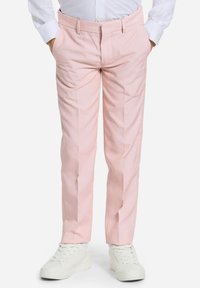 Pantalones rosa con un corte ajustado y bolsillos laterales. El material es suave y presenta un plisado en la parte delantera, combinado con zapatillas blancas.