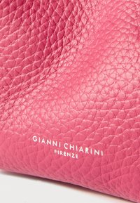 Rosa lærveske med teksturert overflate. Har preget merkevare "GIANNI CHIARINI FIRENZE" i hvitt nederst.