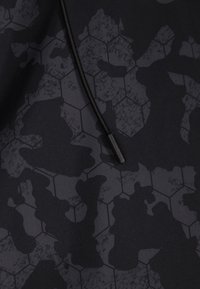 Stof negru cu un model hexagonal în nuanțe variate de gri. Include un șnur cu un aglet negru.