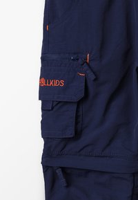 Navy blue cargo trousers made from lightweight fabric featuring orange stitching, a zippered pocket, and a logo patch on the side.
