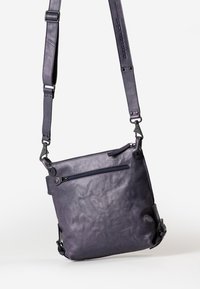 Borsa a tracolla in pelle di colore viola scuro, con una texture liscia, tracolla regolabile e una tasca anteriore con zip e hardware in metallo.