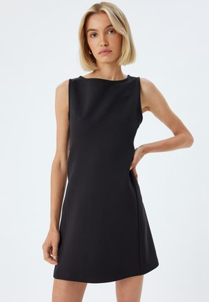 Robe noire sans manches avec une silhouette ajustée, en tissu lisse, décolleté bateau et poches latérales. Design minimaliste avec des lignes épurées.