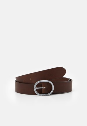 Ceinture en cuir marron roulée avec une boucle ovale en métal argenté centrée sur fond blanc.