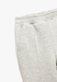 Grå joggers lavet af blød, struktureret stof med elastisk talje og to sidelommer, med en afslappet pasform og subtil meleret mønster.
