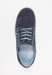 Scarpa lacci in suede blu scuro con cuciture azzurre e una fodera interna liscia. Punta arrotondata e suola piatta. Design semplice e pulito.