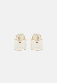 Hvide sneakers med en struktureret guldslangeprint hæl. Har en flad sål og et minimalistisk design med en diskret guldaccent.