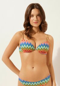 Buntgestreiftes Bikini-Set mit einem Zickzackmuster in leuchtenden Rottönen, Blau, Orange und Grün. Weicher Stoff mit verstellbaren Trägern.