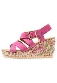 Sandalo con zeppa in camoscio rosa, con cinturini incrociati, fibbia dorata, piattaforma in juta intrecciata e ricami floreali rosa e verdi sui lati.