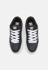 Schwarze Leder-Sneaker mit weißen Schnürsenkeln und einer weißen Gummisohle. Zu den Merkmalen gehören eine perforierte Zehenpartie, ein gepolsterter Kragen und ein Markenlogo auf der Zunge.
