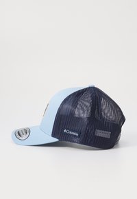 Zils beisbola cepure ar cieto priekšpusi un jūras zila sieta aizmuguri. Iekļauj kontrastējošu logotipu un regulējamu snapback aizdari.