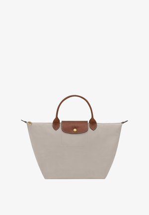 Light gray tote bag made of durable fabric. Features a brown leather handle and flap with a gold snap button. Zippered side compartment included.