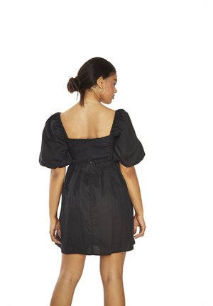 Schwarzes kurzes Kleid mit Puffärmeln, einem gerafften Rücken und einer A-Linien Silhouette. Hergestellt aus leichtem Stoff mit strukturiertem Finish.