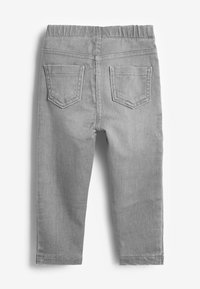 Pantalon en denim gris avec une taille élastique douce, deux poches arrière et une simple couture décorative. Coupe droite et texture lisse.