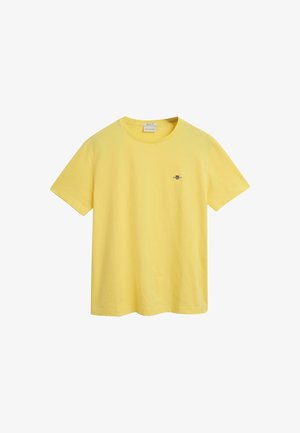 T-shirt in cotone giallo con maniche corte e colletto rotondo; presenta un piccolo logo ricamato sulla parte sinistra del petto.