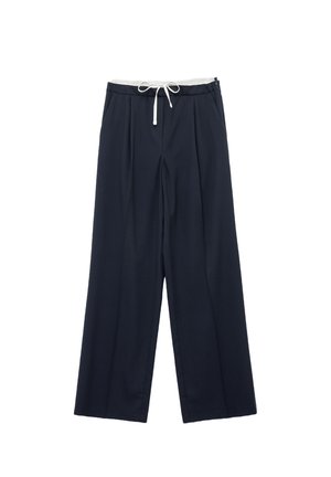 Navy wijde broek met een witte trekkoord in de taille. Kenmerkt zich door plooien en een gladde textuur. Gemaakt van een lichtgewicht stof.