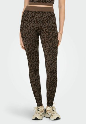 Hnědé legíny s leopardím potiskem a ribbed texturou, vyšším pasem, doplněné světlými teniskami.