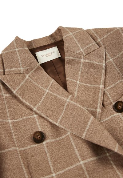 Cappotto in lana a scacchi marrone con colletto a scialle, foderato in marrone e due bottoni scuri. Presenta una texture morbida e un design classico doppiopetto.