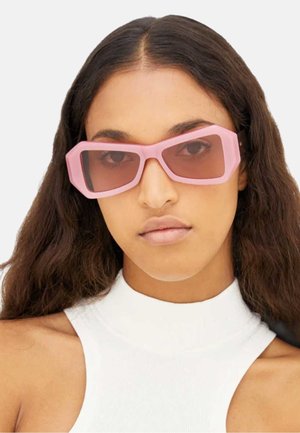 Occhiali da sole rosa oversize a forma rettangolare con lenti sfumate e finitura opaca, caratterizzati da bordi audaci e dettagli di design eleganti.