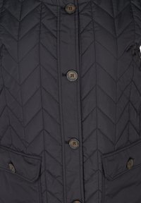 Gilet matelassé noir avec un motif en chevron, cinq boutons marron et deux poches avant à rabat. Tissu lisse avec une finition mate.