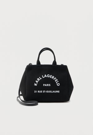 Crna pravokutna torba s dvije ručke i odvojivim remenom, s bijelim natpisom: "KARL LAGERFELD PARIS 21 RUE ST-GUILLAUME."