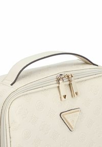 Sac synthétique texturé blanc avec une poignée supérieure. Doté d'une fermeture éclair et de quincaillerie dorées, d'un logo embossé et d'un emblème triangulaire Guess à l'avant.