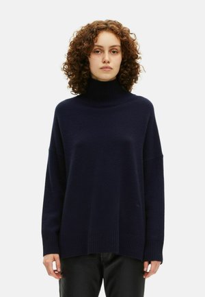 Granatowy sweter typu golf w miękkim dzianinie, z luźnym krojem, prążkowanymi mankietami i dołem, o teksturowanej tkaninie i opadających ramionach.