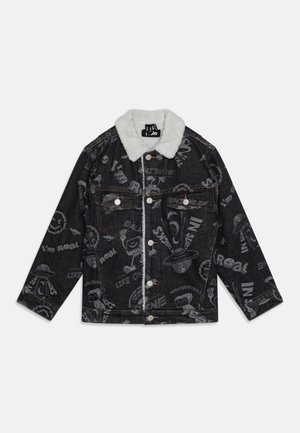 Veste en jean noire avec col sherpa blanc, fermeture à boutons sur le devant, poches poitrine, et motifs graphiques imprimés ainsi que texte sur toute la surface.