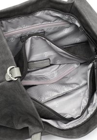 Interno di una borsa a tracolla in tessuto grigio con scomparti multipli, incluso un taschino con zip e una fodera decorata. Accenti argentati della zip visibili.
