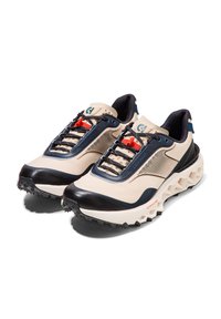 Beiga och marinblå sportskor med en texturerad ovandel, gummisula, röda skosnören och nätpaneler för andning. Har en dämpad sula.