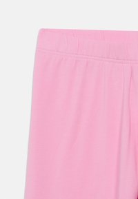 Rosa Leggings aus einem glatten, dehnbaren Stoff. Mit elastischem Bund und nahtlosem Design ohne Taschen oder Muster.