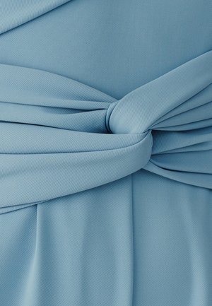 Tela azul claro con un detalle de nudo ancho que crea pliegues suaves y textura en un material liso y tejido.