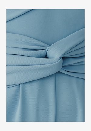 Tela azul claro con un detalle de nudo ancho que crea pliegues suaves y textura en un material liso y tejido.