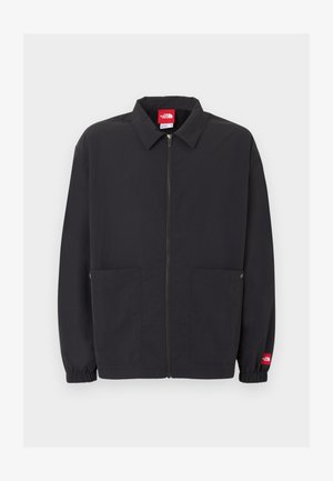 Fekete cipzáras dzseki gallérral, két első zsebbel, elasztikus mandzsettával és kis piros logócímkével a bal ujján.