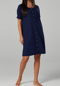 Marinblå bomulls klänning med korta ärmar, knapprad fram, avslappnad passform och knälång fåll. Slät textur och enkel design.