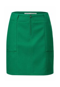 Grön kjol i ett strukturerat tyg, med en dragkedja framtill, två sidofickor och en figurnära passform, samt synliga sömmar.