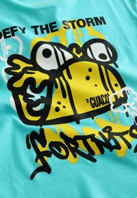 Tricou de culoare albastru deschis, cu un brotac cartoon galben și textul "ÎNFRUNTĂ FURIA" în negru, prezentând picături și un design de bulă de dialog.