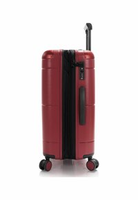 Roter Hartschalenkoffer mit einem schwarzen Reißverschluss, ausziehbarem Griff und 360-Grad-Rädern. Verfügt über ein Zahlenschloss und eine strukturierten Oberfläche.