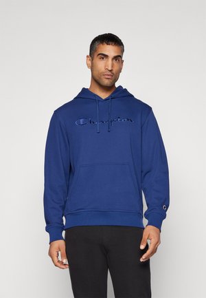 Sudadera azul marino con bolsillo frontal, capucha ajustable con cordón y logotipo "Champion" bordado. Puños y dobladillo acanalados con el logotipo icónico en la manga.