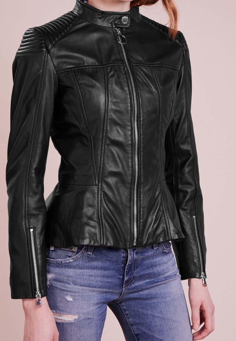 Černá kožená motocyklová bunda s přiléhavým střihem, žebrovanými rameny, dvěma předními zipy a strukturovanými detaily. Obsahuje peplum lem.