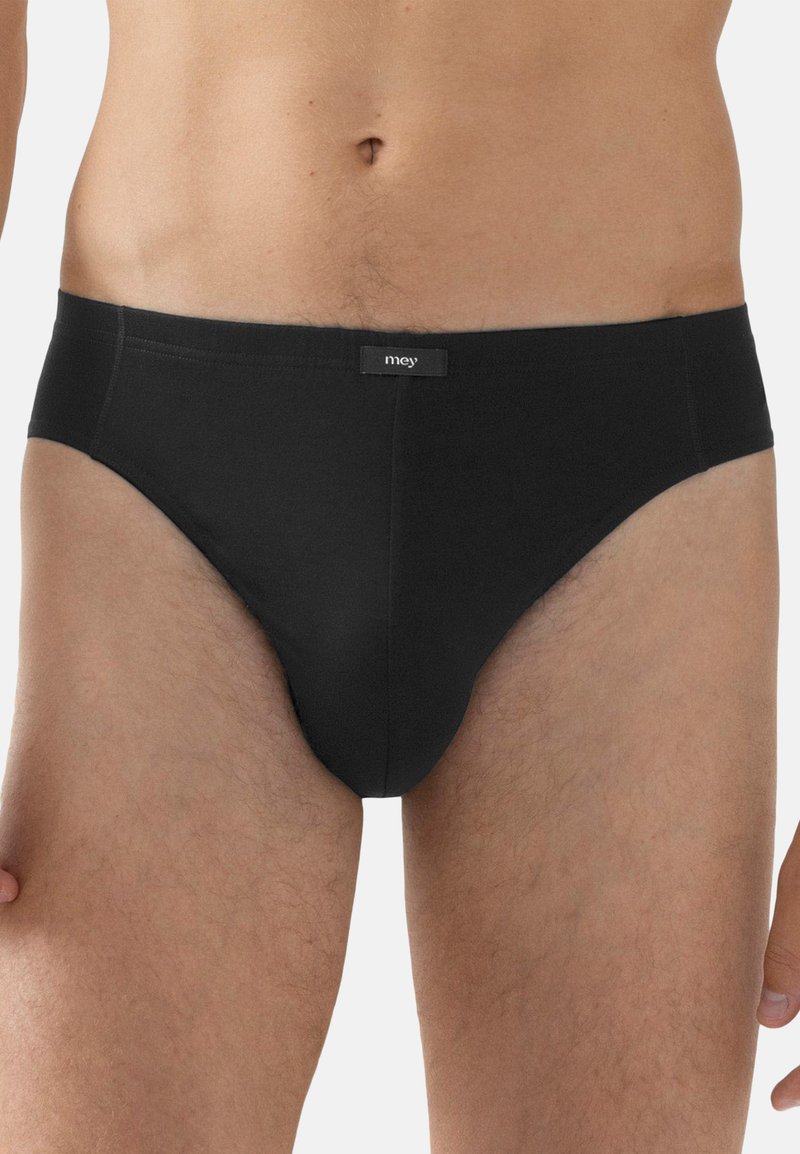 Männlicher Oberkörper, der eng anliegende schwarze Unterhosen mit dem "mey"-Label am Bund trägt, Haut von der Taille bis zu den Oberschenkeln oben zeigend.