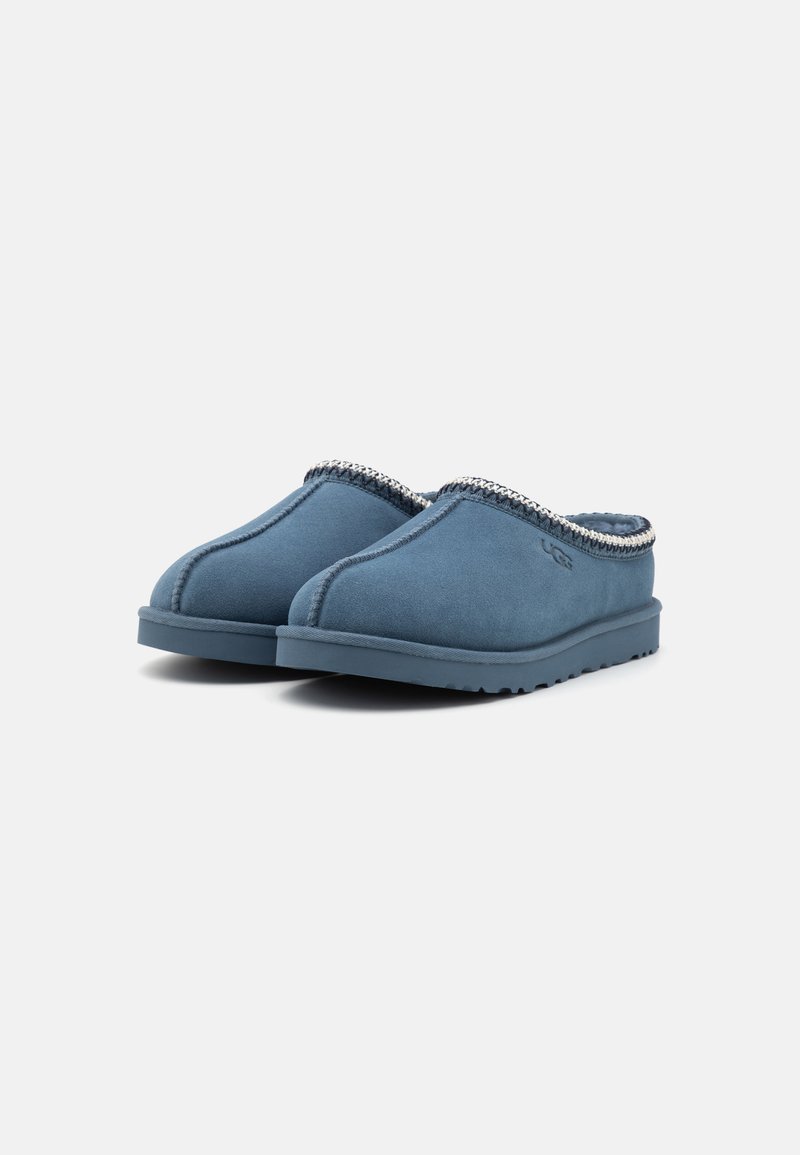 Chaussons en cuir suédé bleu avec une finition texturée et des coutures décoratives le long du col. Semelle en caoutchouc pour une meilleure adhérence.