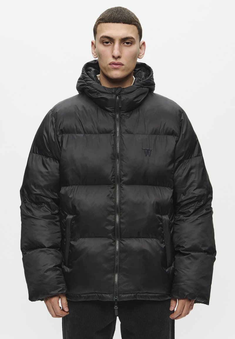 Chaqueta acolchada negra hecha de nailon brillante. Presenta una capucha, cierre frontal y paneles acolchados. Logo sutil en el pecho. Textura suave.