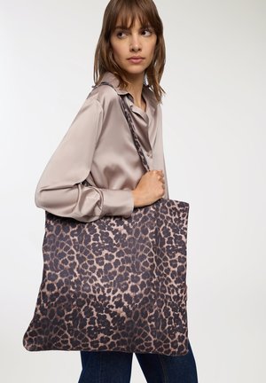 Borsa a tracolla con stampa leopardata realizzata in un tessuto morbido, caratterizzata da macchie in marrone scuro e beige. Design ampio e tracolla per un facile trasporto.
