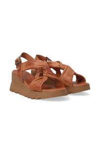 Bruine leren sandalen met een dikke zool en gekruiste banden, voorzien van een verstelbare gesp. Ontworpen voor comfort en stijl.